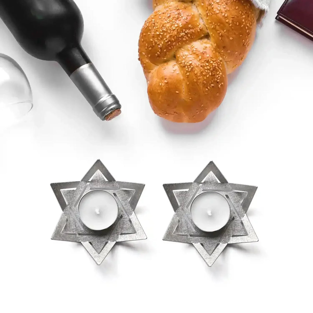 Modern Star of David Shabbat candle holders with challah and wine โ lifestyle table setting