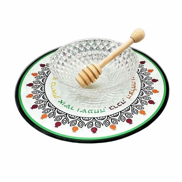 סט להגשת תפוח בדבש הכולל צלוחית מזכוכית (20 סמ) מחוסמת עם עיטורי רימונים וברכות. מכיל דבשון, וצלוחית קריסטל