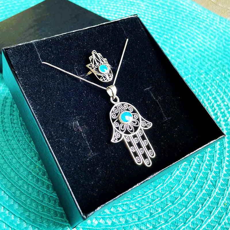 סט מהמם של תליון חמסה מכסף 925 עם עיטורי פיליגרין ואבן אופל + טבעת חמסה תואמת מעלפת מכסף 925 עם עיטורי פיליגרין משובצת אבן אופל כחולה. מגיע עם אריזת מתנה מיוחדת בעבודת יד ושליח עד הבית