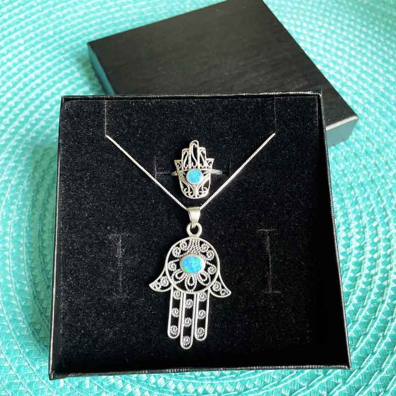 סט מהמם של תליון חמסה מכסף 925 עם עיטורי פיליגרין ואבן אופל + טבעת חמסה תואמת מעלפת מכסף 925 עם עיטורי פיליגרין משובצת אבן אופל כחולה. מגיע עם אריזת מתנה מיוחדת בעבודת יד ושליח עד הבית