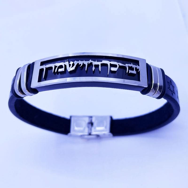 צמיד "יברכך ה' וישמרך" לגבר. עשוי עור סינטטי שחור עם עיטורי "מגני דוד". סה"כ אורך 21 ס"מ(ניתן לקיצור). על גבי פלטת פלדת אל-חלד מושחרת ישנה חריטת CNC איכותית מוזהבת עם הכיתוב: "יברכך ה' וישמרך". הצמיד המושלם לגבר או אישה. צמיד עמיד מאוד! מתנה מקורית לגבר לכל אירוע – יום הולדת, גיוס לצה”ל, שחרור לצה”ל, מתנה למפקד/לבעל/לבן זוג וכו. צמיד עמיד מאוד ואיכותי. לא משחיר או מחליד. ולא מחליף צבע לעולם! אפשר להרטיב, להכניס למים, ים, ג’קוזי, לבריכה. במבצע! מגיע עם קופסת מתנה.