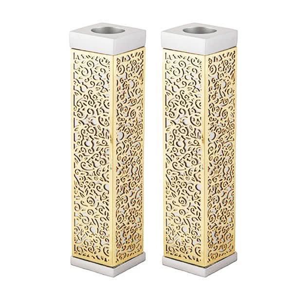 זוג פמוטים מרובעים גבוהים מהודרים ( 14.5 * 3 * 3 ס"מ ) אלומיניום ונחושת. עם עיטורי מגזרות מתכת בחיתוך לייזר מדויק המעטרות את הפמוט. גימור זהב. מעוצב ומיוצר ע"י אמן יאיר עמנואל.